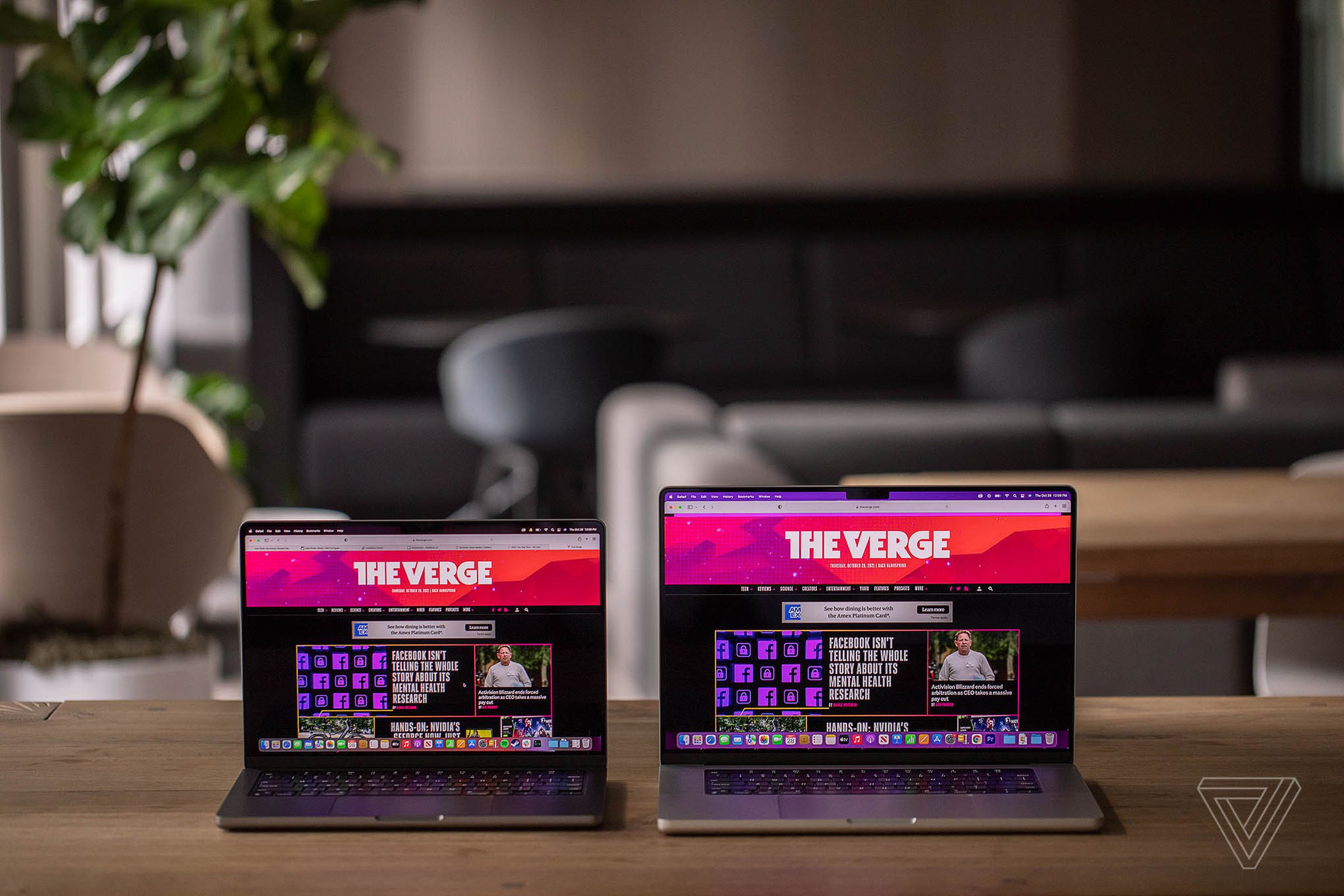 MacBook Pro 14 dan MacBook Pro 16 berdampingan di atas meja, keduanya menampilkan beranda The Verge.